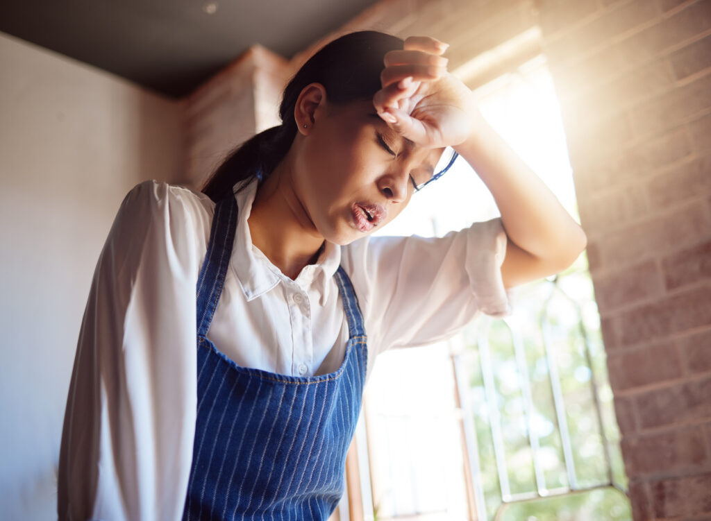 Woman tired from working in a restaurant that is hot and humid | RAM